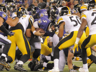 Ravens quarterback Joe Flacco, center, keeps the ball on a fourth-down conversion in the second quarter against the Pittsburgh Steelers at M&T Bank Stadium. (Karl Merton Ferron, Baltimore Sun)
